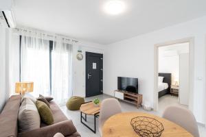 a living room with a couch and a table at Thalassa & Thalassa Prive Residential Complex in Ofrínion