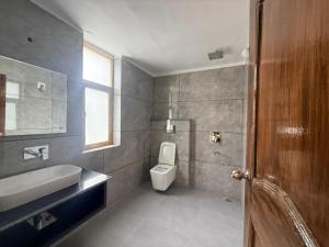 a bathroom with a white toilet and a sink at Natures View Residency in Hundar