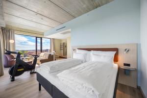 a bedroom with a bed and a room with a gym at Comfort Hotel Grimstad in Grimstad