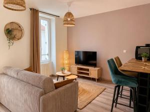 a living room with a couch and a tv and a table at Au coeur de Vernon - Appartement 4 pers - à 10min Giverny in Vernon