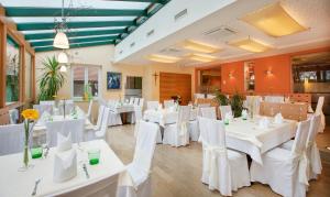 a dining room with white tables and white chairs at Landhotel Schwabenhof in Heiligenbrunn