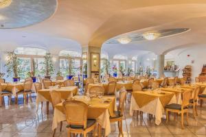 a restaurant with tables and chairs in a room at Aragona Palace Hotel & Spa in Ischia Town