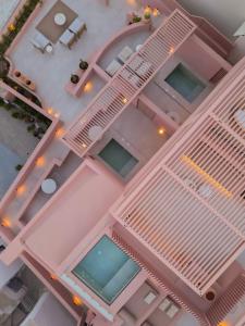 an overhead view of a pink building with a pool at Thianne Luxury Suites in Fira