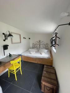 a bedroom with a bed and a desk and a yellow chair at Il giardino di Lallo in Barrea