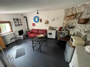 a living room with a red couch and a kitchen at Il giardino di Lallo in Barrea