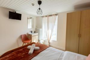 ein Schlafzimmer mit einem Bett, auf dem ein Teddybär liegt in der Unterkunft Le Zigzag in Retournac