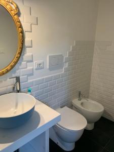 a bathroom with a sink and a toilet and a mirror at Il giardino di Lallo in Barrea