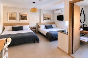a hotel room with two beds and a television at Hostal Casa Miguel Marbella in Marbella