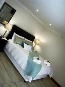 a bedroom with a bed with two towels on it at Zamar Guest House in Caledon
