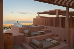 a building with stairs with a view of the ocean at Thianne Luxury Suites in Fira
