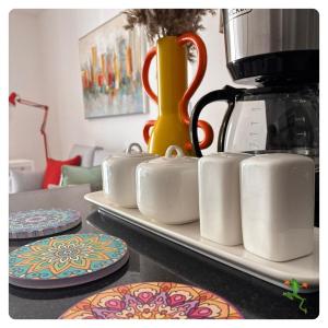 a row of white mugs on a tray on a table at The Quiet Creative, Corporate-Ready 1BR in Tatu City
