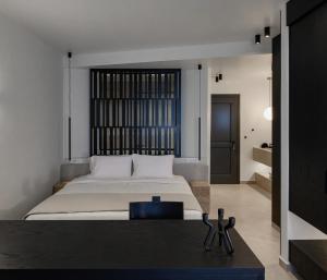 a bedroom with a large bed and a black table at Thianne Luxury Suites in Fira