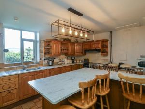a kitchen with wooden cabinets and a table with chairs at Cairbre House in Dungarvan