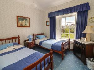 a bedroom with two beds and a window at Cairbre House in Dungarvan
