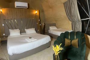 a hotel room with two beds and a chair at Magic rum hussen Luxury in Wadi Rum