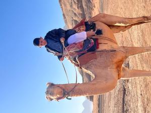 two people are climbing on a rock wall at Magic rum hussen Luxury in Wadi Rum