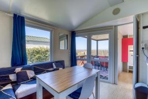 a living room with a couch and a table at Location Mobile home in Marseillan