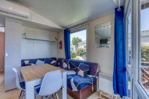 a room with a table and chairs and a window at Location Mobile home in Marseillan