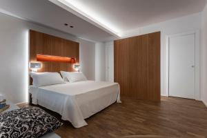 a bedroom with a large white bed with a wooden headboard at Velino Business Suite in Avezzano