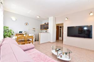 a living room with a pink couch and a table at House Pavicini 333 in Pavicini