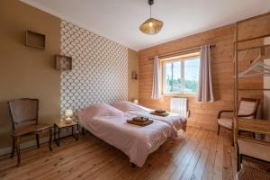 a bedroom with a bed and a window at Les Brimbelles in Brû