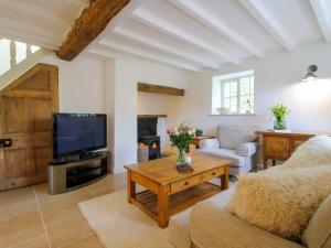 a living room with a tv and a couch and a table at 5 Shrewsbury Road in Much Wenlock