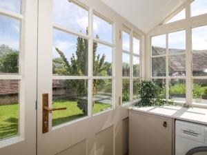 a kitchen with large windows and a white door at 5 Shrewsbury Road in Much Wenlock +41 photos
