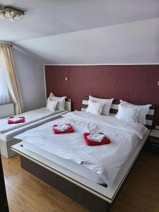 two beds with red napkins on top of them at Casa Borza in Alba Iulia