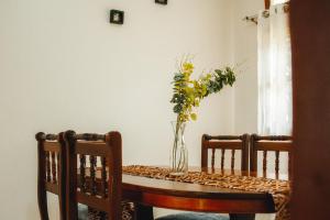 a vase of flowers on a table with two chairs at JOSIRE Residence in Entebbe +13 photos