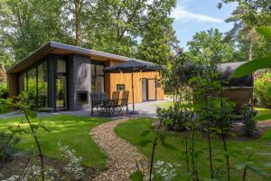 a cottage in the garden with a patio at Park Berkenrhode in Wekerom