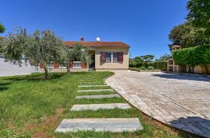 a house with a brick walkway in front of a yard at House Pavicini 333 in Pavicini