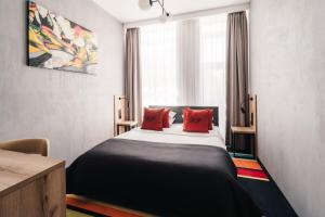 a bedroom with a large bed with red pillows at Hotel Polonez in Krakow