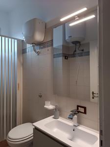 a bathroom with a sink and a toilet and a mirror at KolymBeddra in Agrigento