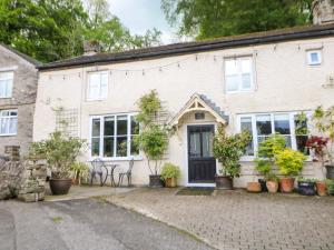 a brick house with potted plants in front of it at Bargate Cottage in Castleton
