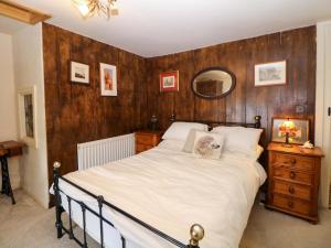 a bedroom with a bed and a wooden wall at Bargate Cottage in Castleton