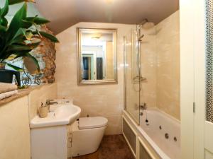a bathroom with a sink and a toilet and a tub at Bargate Cottage in Castleton +46 photos