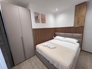 a small bedroom with a bed with towels on it at Palmera Escape Radhime in Vlorë +28 photos