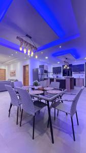 a dining room with a table and chairs and a kitchen at VLAP Residence in Baie du Tombeau