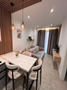 a living room with a table and a couch at Palmera Escape Radhime in Vlorë