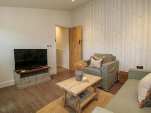 a living room with a tv and a couch and a table at Thyme Away in Bucknell