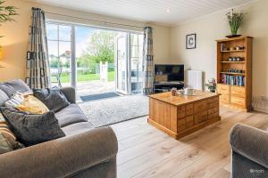 a living room with a couch and a tv at Windrush Lake 88, Waterside in South Cerney