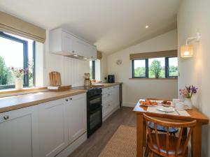 a kitchen with white cabinets and a wooden table at Thyme Away in Bucknell