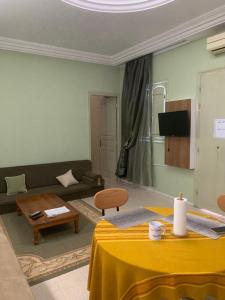 a living room with a table and a couch at Le Typique Djerbien in Houmt Souk