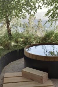 a wooden bench sitting next to a hot tub at Casa de São Lourenço - Burel Panorama Hotel - member of Relais & Châteaux in Manteigas
