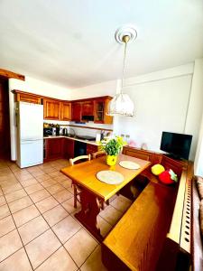 a kitchen with a wooden table and a dining room at Casa Furlan in Calalzo