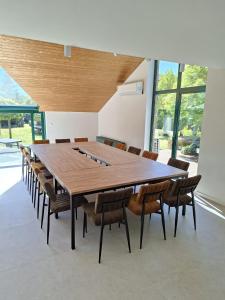 a large wooden table and chairs in a room at De Villadroom in Hasselt