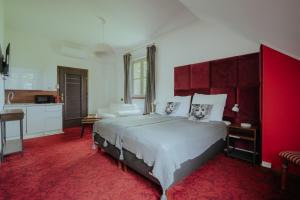 a bedroom with a large bed and a red carpet at Dwór Ujazdowski in Nielisz