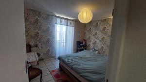 a small bedroom with a bed and a window at ROMELLA's ROOM in Saint-Projet