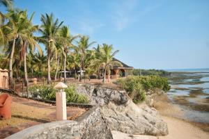 a view of a beach with palm trees and a house at M Villa’s Farm Resort in Romblon