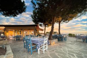 a restaurant with blue and white tables and chairs at Apartment Theia with sea and sunset views, the Resort in Aphrodite Hills in Kouklia